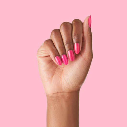 Hand with vibrant Hot Strawberry polish in bright strawberry pink perfect for at-home manicure and pedicure care