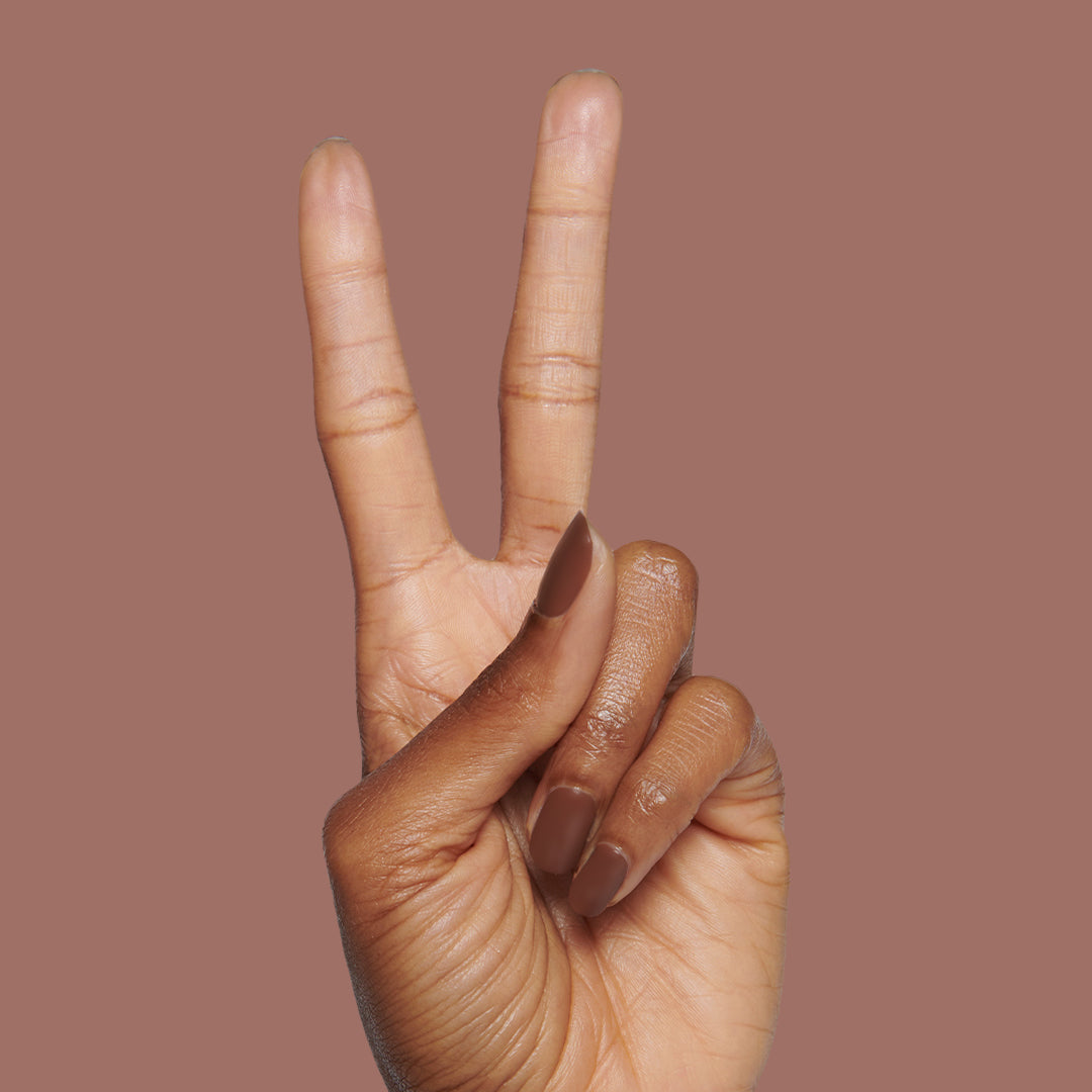 Hand with matte brown nails in a peace sign gesture featuring The Matte Top Coat for a smooth, durable manicure finish