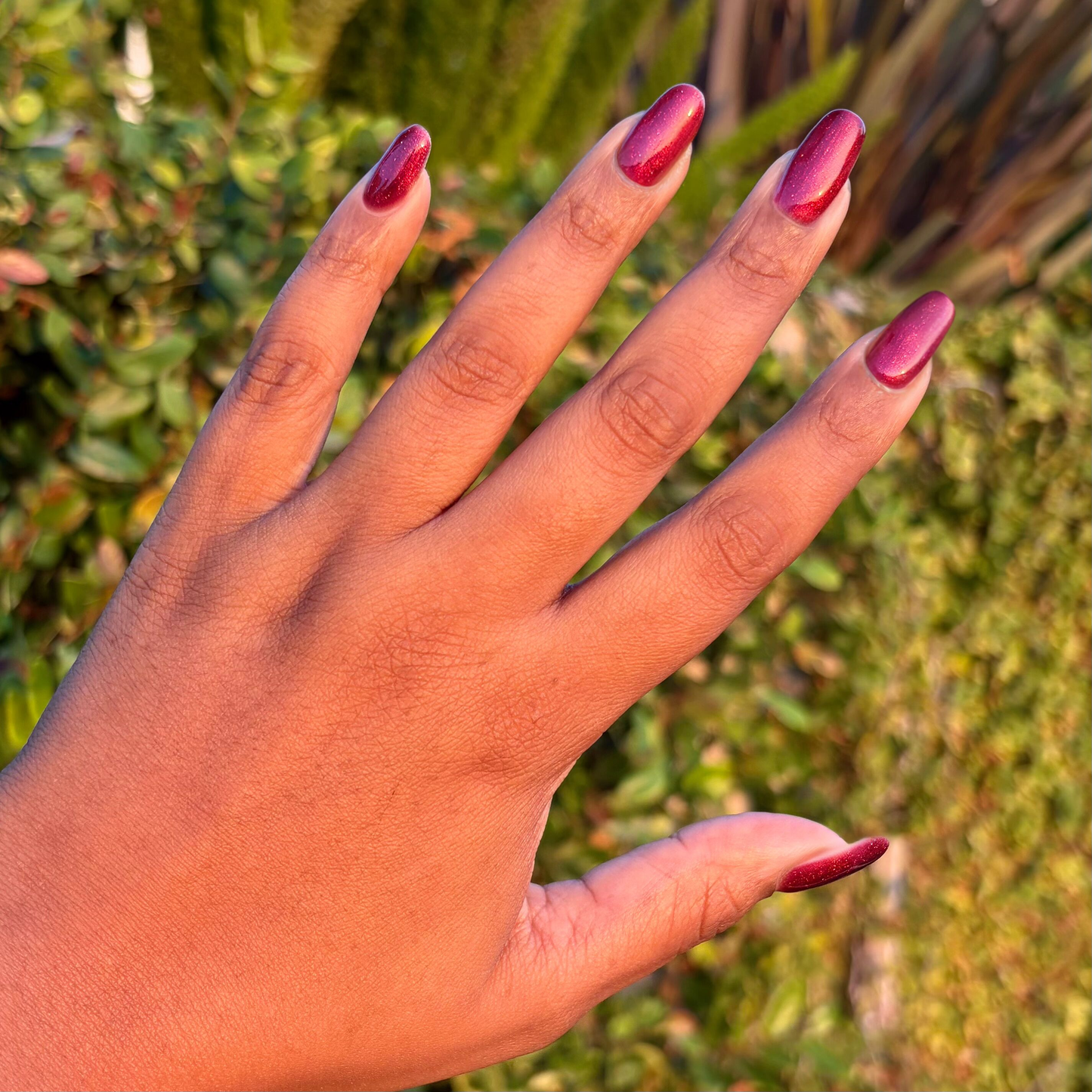 Budget? What Budget Gel deep rose-orange duochrome polish on medium-length nails for a chic manicure by Olive and June