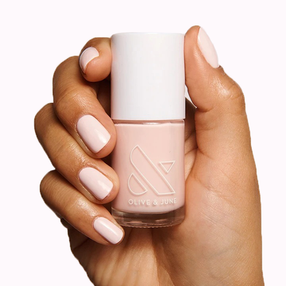 Hand holding a bottle of GH nail polish in an opaque baby pink perfect for a glowy, versatile manicure at home