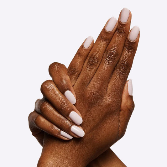 Hands with nails coated in TT, an almost pastel lavender gel polish with soft grey undertones for an elegant mani