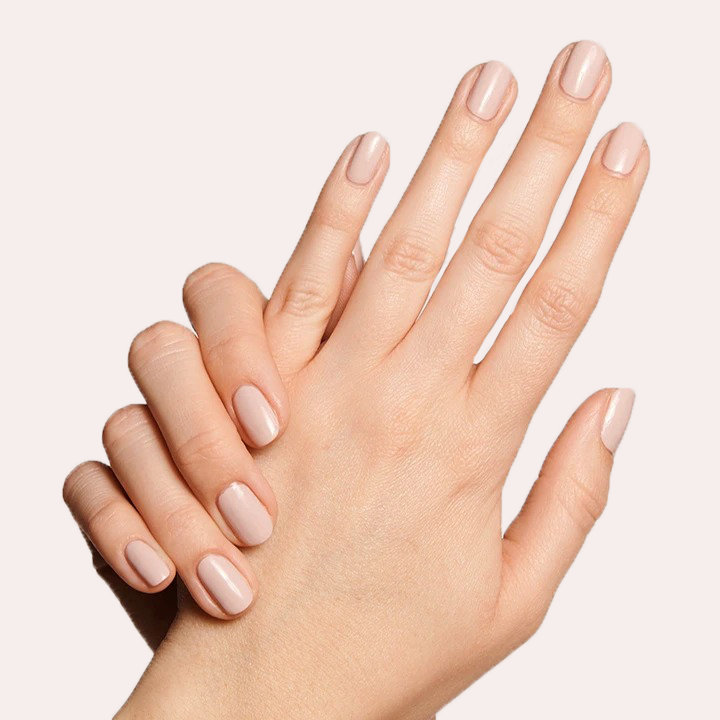 Hands with nails painted in CDJ showing a creamy neutral gel polish perfect for an elegant at-home manicure