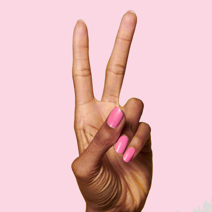 Hand showing peace sign with nails painted Grateful & Kind pure pink gel polish for a smooth at-home manicure