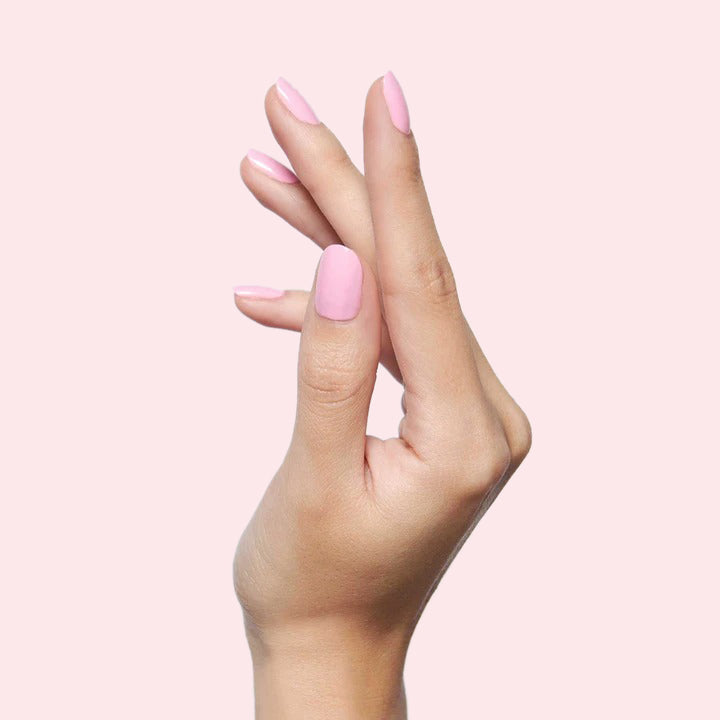 Hand with nails polished in soft pink shade SE by Olive and June, showcasing a smooth and fresh at-home manicure look