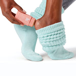 The Mint Slumber Party Set with moisturizing heel balm and cozy mint green socks on feet for overnight care