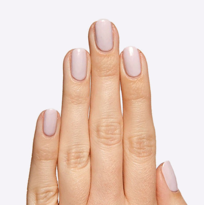 Hand with nails in TT gel polish, a soft pastel lavender with subtle grey undertones for a refined manicure