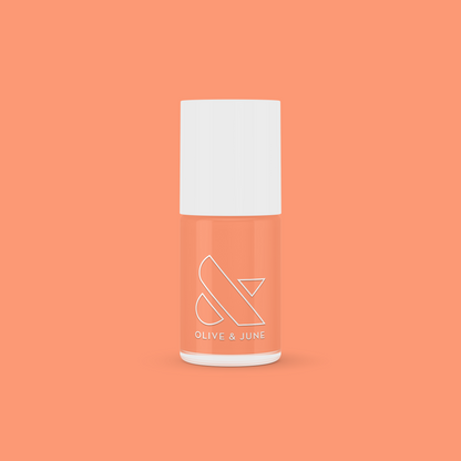 Olive and June Wild & Free gel polish bottle in fierce coral shade on a bright coral background for at-home mani.