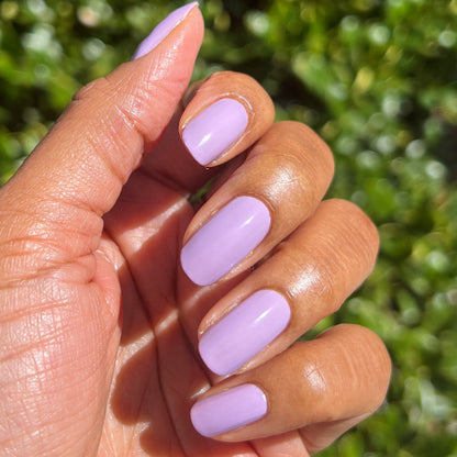 Hand with nails coated in You're Invited lilac gel polish by Olive and June for a smooth, durable manicure finish