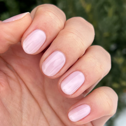 Close-up of hand with nails painted in sheer pink Strawberry Scone polish for a natural at-home manicure