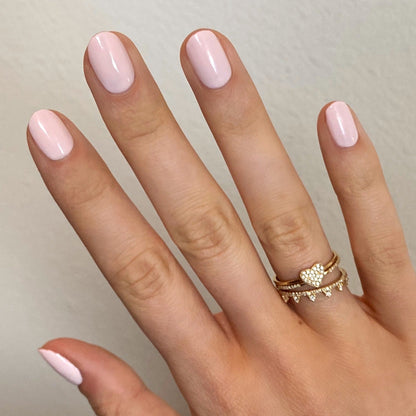 Hand with nails painted in GH, a soft opaque baby pink polish ideal for a radiant and versatile manicure at home
