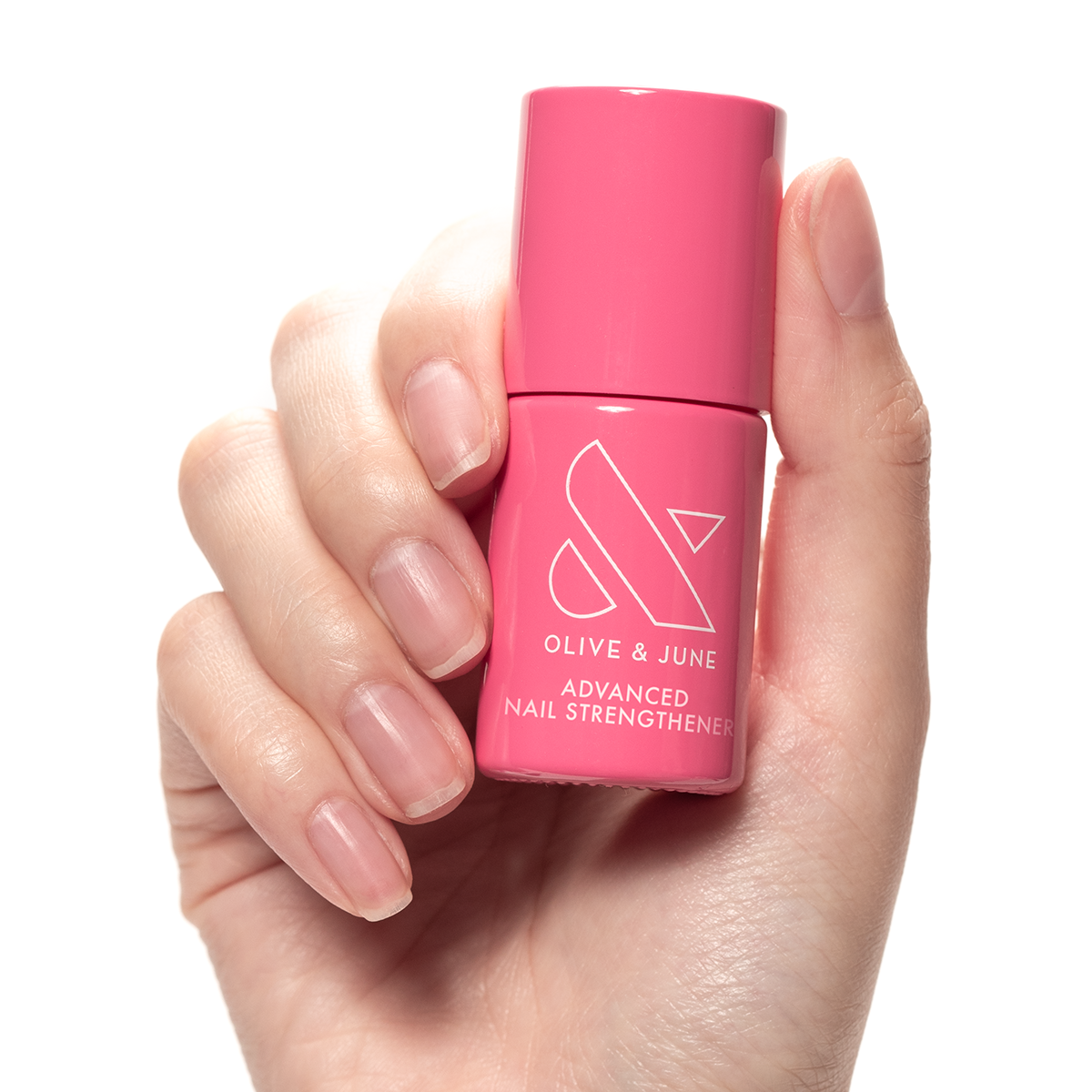 Hand holding Olive and June Advanced Nail Strengthener bottle with natural nails, promoting nail strength and growth.