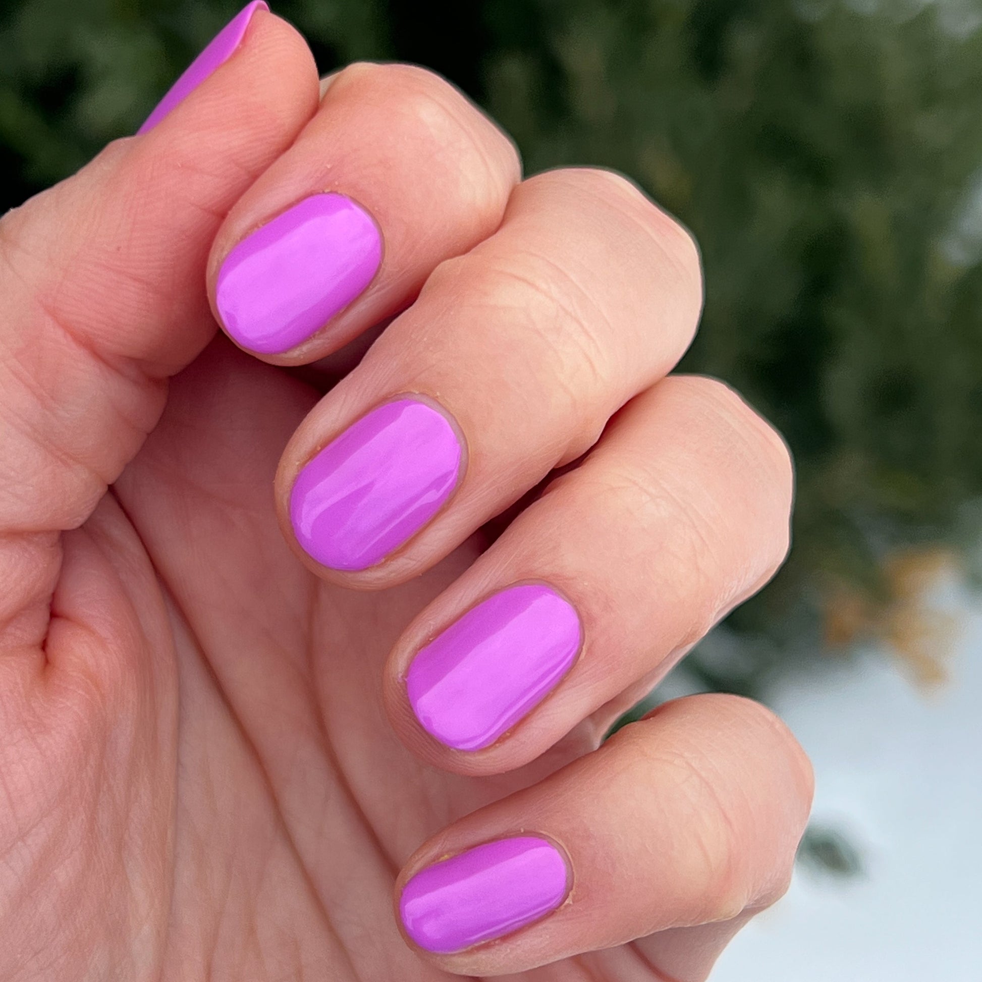 Hand with nails coated in glowing soft magenta Jam, Please polish for a smooth, long-lasting manicure by Olive and June
