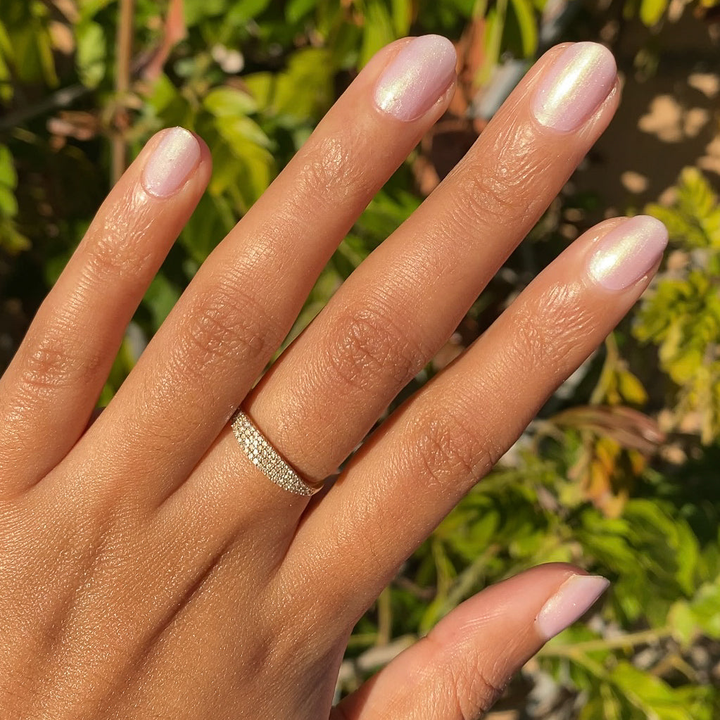 Hand with natural nails painted in shiny Purple Puka gel polish showing a soft lavender iridescent manicure
