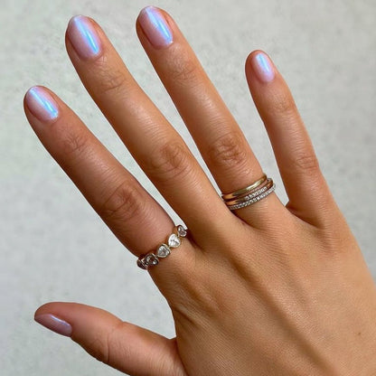 Hand with nails painted Pink Goldfish sheer iridescent polish showing a luminous manicure with delicate shimmer