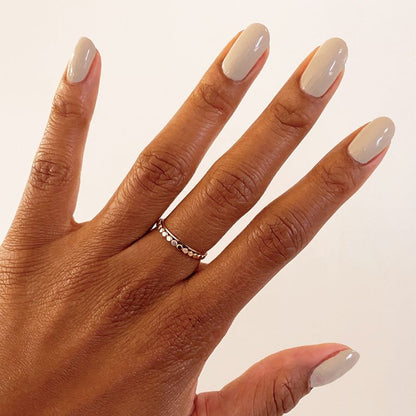 Hand with nails coated in CDJ gel polish, a cool creamy neutral shade ideal for at-home manicures by Olive and June