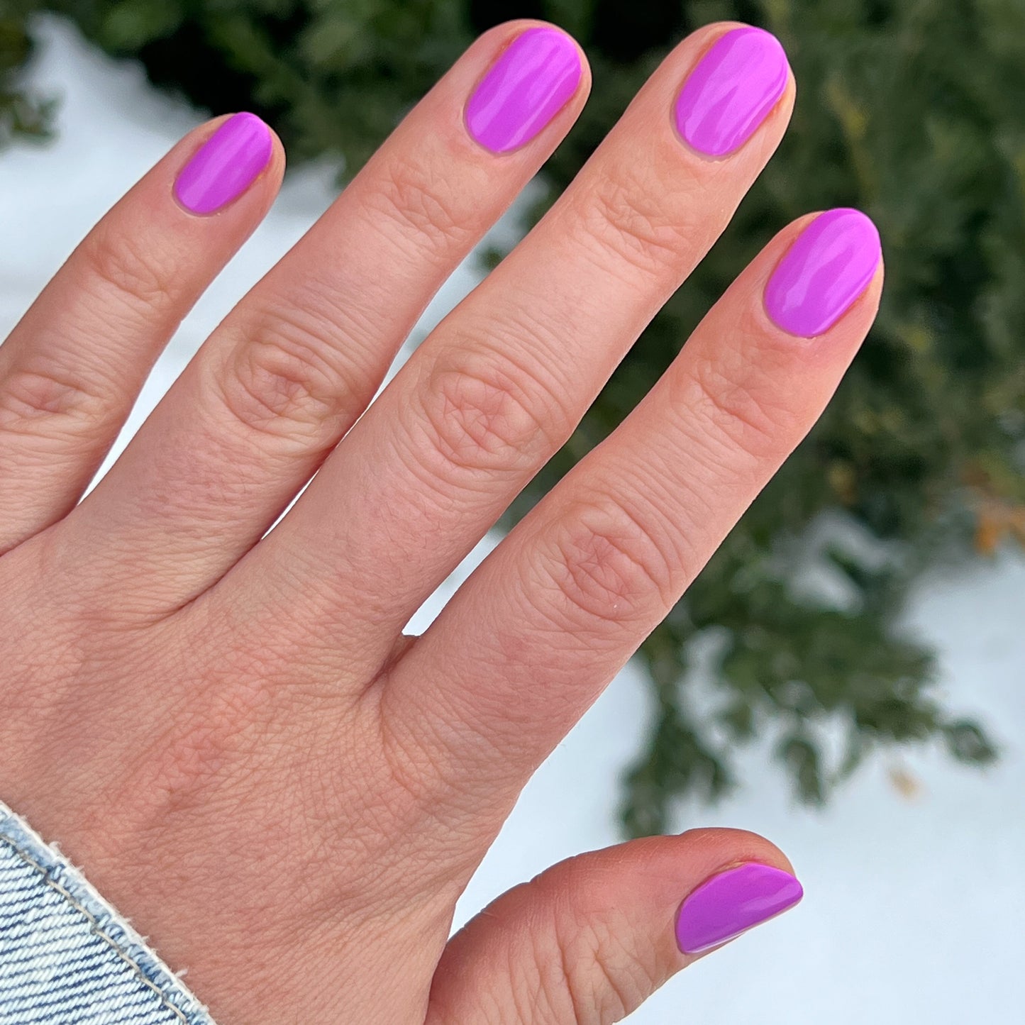 Hand with nails coated in vibrant glowing magenta Jam, Please polish for a smooth long-lasting manicure by Olive and June