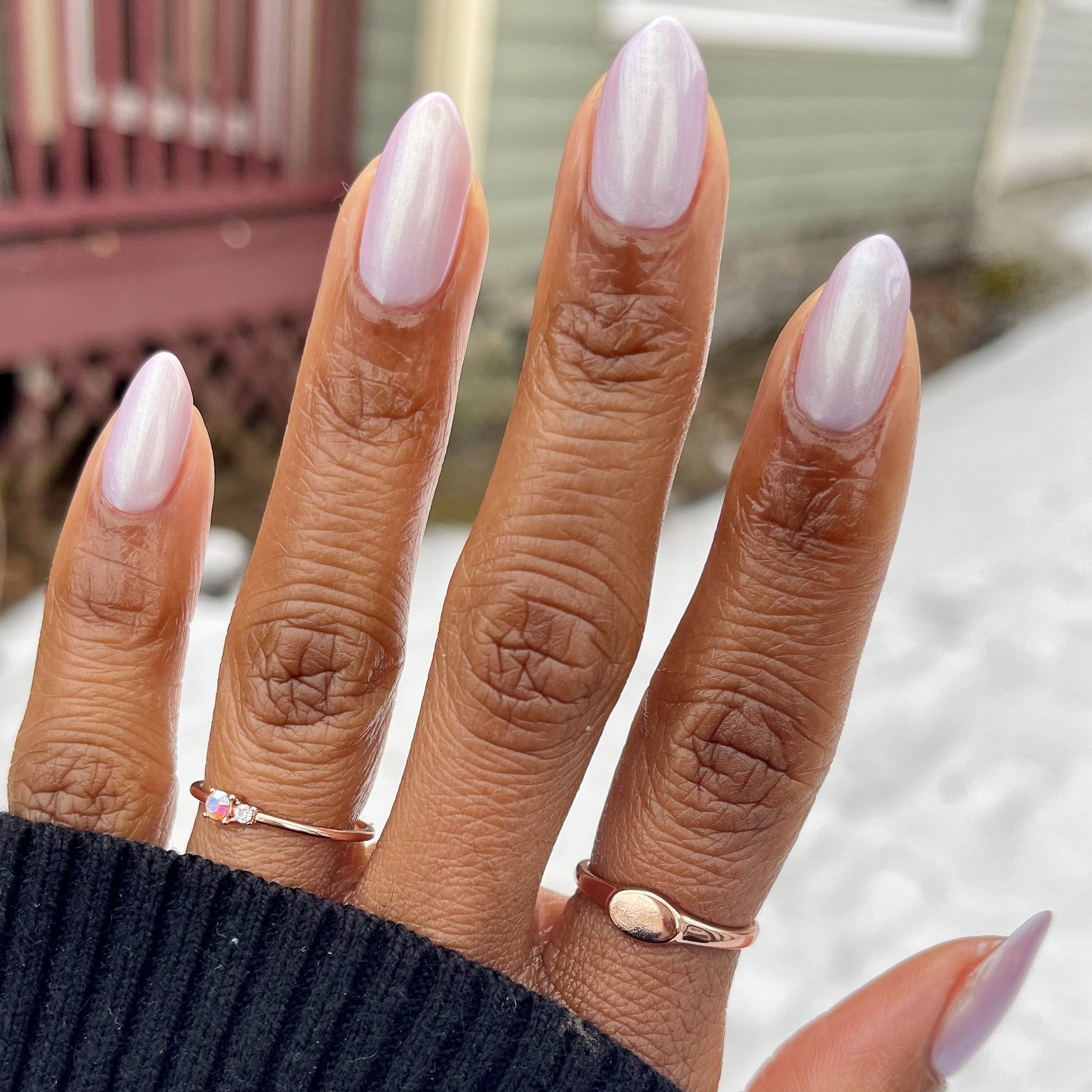 Hand with almond-shaped nails painted in glossy Purple Puka gel polish showing a creamy lavender manicure