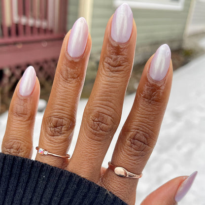 Hand with almond-shaped nails painted in glossy Purple Puka gel polish showing a creamy lavender manicure