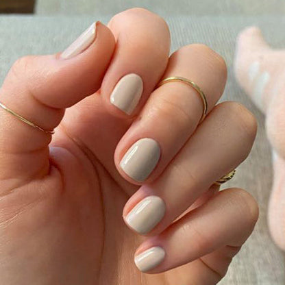 Hand showing nails polished in CDJ, a neutral creamy gel polish by Olive and June for a smooth at-home manicure