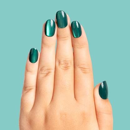 Emerald Magic Velvet - Pressies | Short Medium | Round showing deep green shimmering press-on nails on hand with teal background