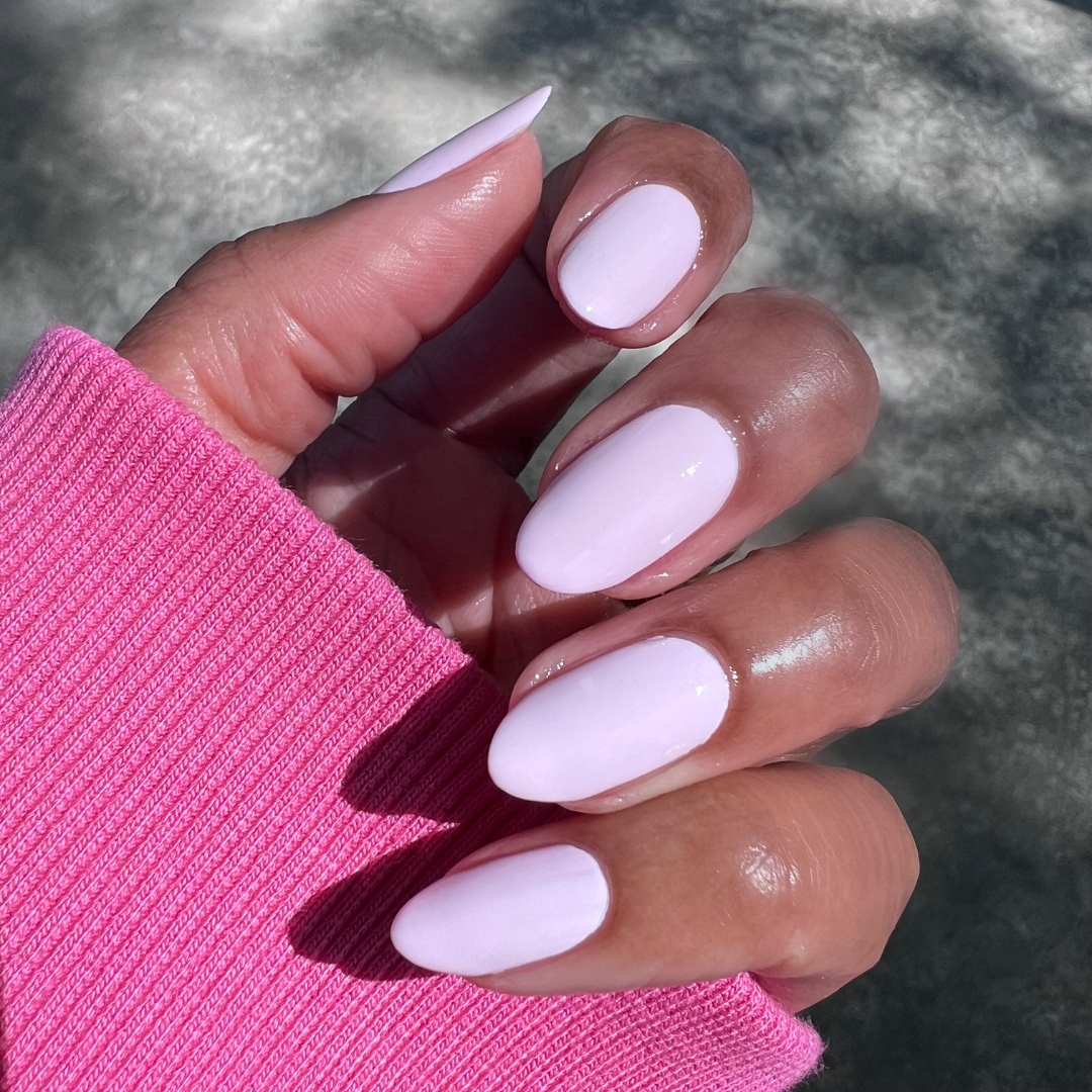 Hand with long, rounded nails painted in Gelato gel polish soft baby pink for a polished, at home mani look