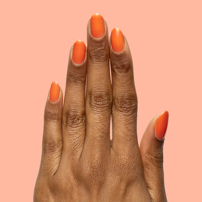 Hand with matte nails painted in I’ll Take Another Spritz for a bright, long-lasting at home mani look