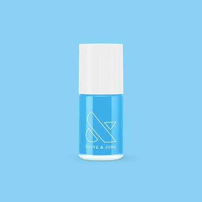Bottle of Megababe Blue gel polish with white cap on solid blue background for vibrant nail color option