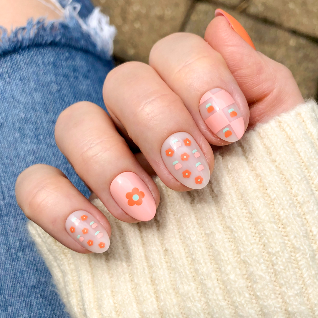 Hand wearing Mixed Quilt Print - Press-On | Short | Almond nails with peach floral and plaid patterns for a cozy mani