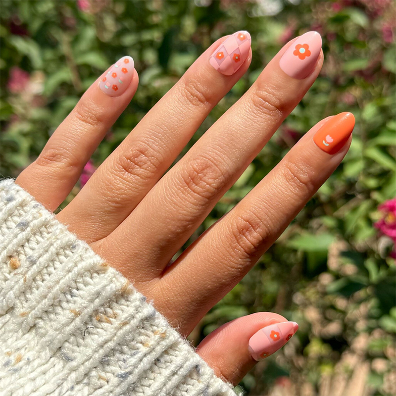 Hand with Mixed Quilt Print - Press-On | Short | Almond nails in warm floral and diamond quilt patterns for a cozy mani