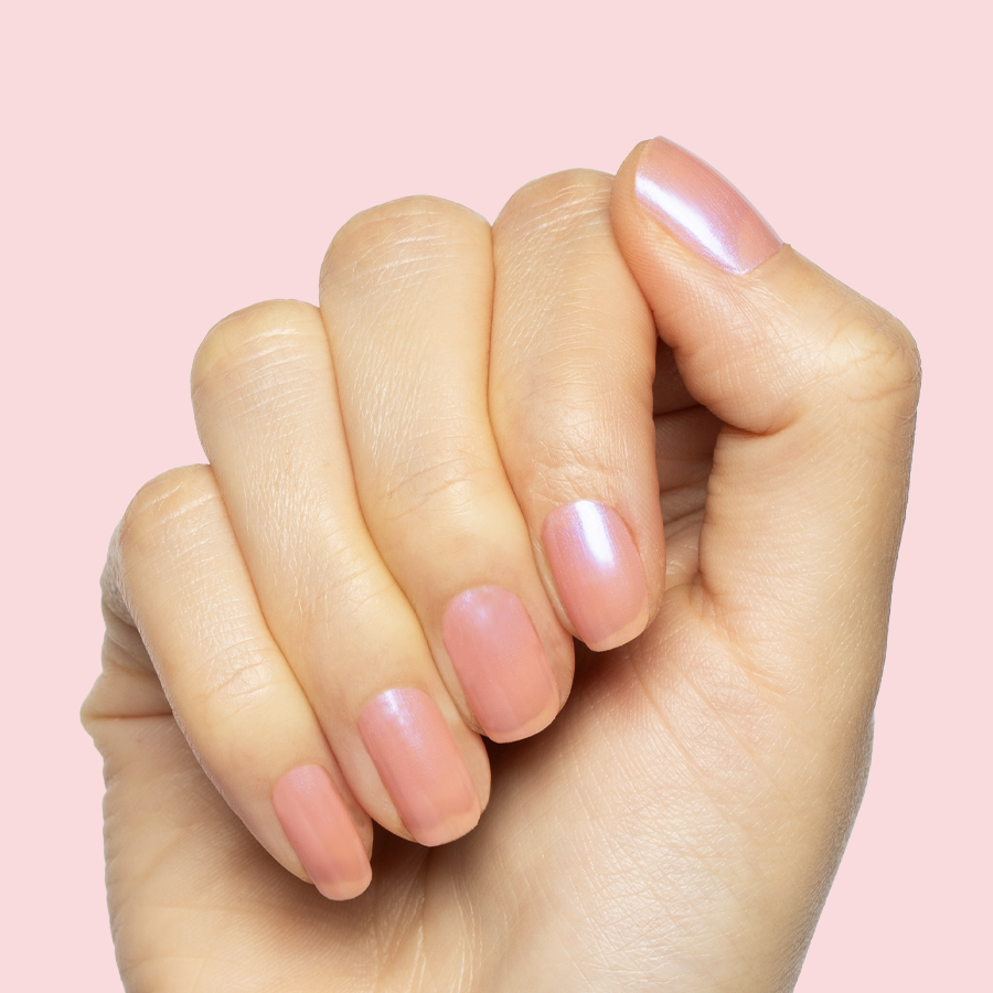 Hand with medium nails painted in sheer iridescent pink-blue Olive Y'all gel polish manicure on light skin tone