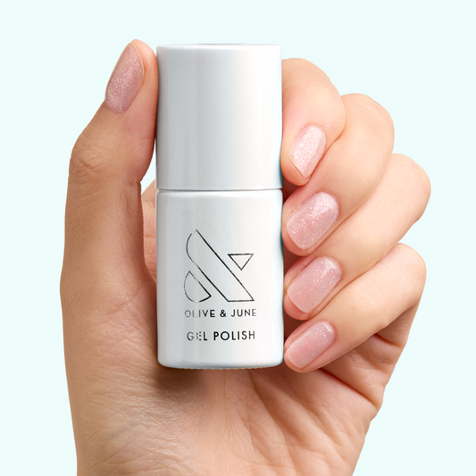 Hand holding DIAMONDS ARE A MANI’S BEST FRIEND Gel with nails polished in sparkly sheer iridescent gel for manicures