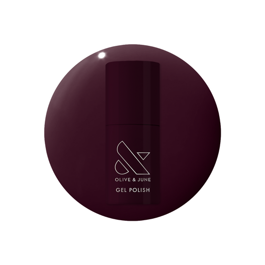 Bottle of Covet - Gel polish in a deep cool plum shade set on a matching gel polish swatch background