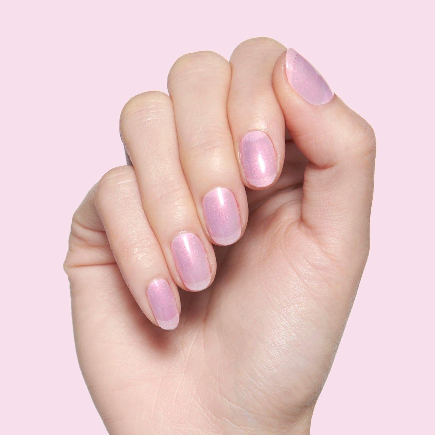 Pink Goldfish sheer pink iridescent nail polish on natural nails for a delicate and luminous at-home manicure