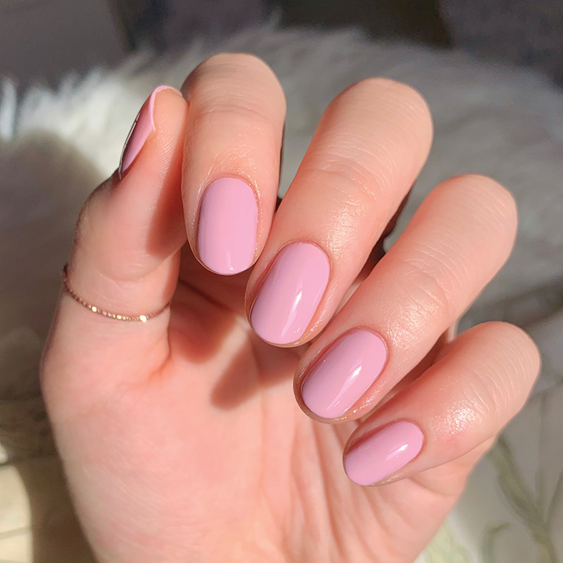 Hand with rounded nails painted in smooth Cockatoo polish by Olive and June for a soft, long-lasting manicure look