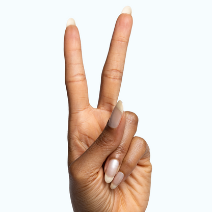 Hand showing peace sign with long nails coated in sheer pearly Freshwater gel polish for an at-home manicure