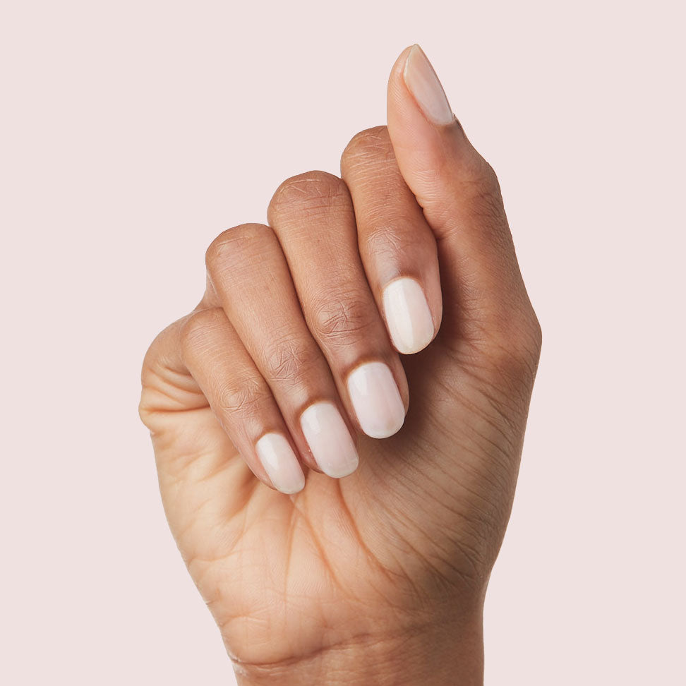 Hand with nails painted in sheer cool pink shade using Strawberry Scone polish for a natural manicure