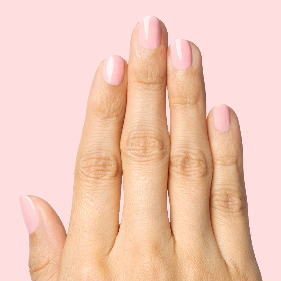 Hand with nails painted in a sheer pink shade using Saltwater Taffy - Gel for a polished at-home manicure look