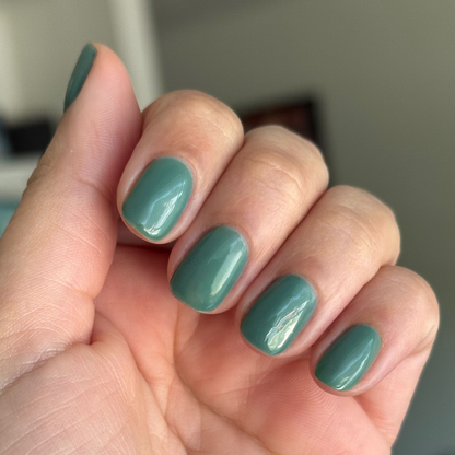 Close-up of short rounded nails painted in Still Life of Flowers - Gel mossy green gel polish on natural skin tone