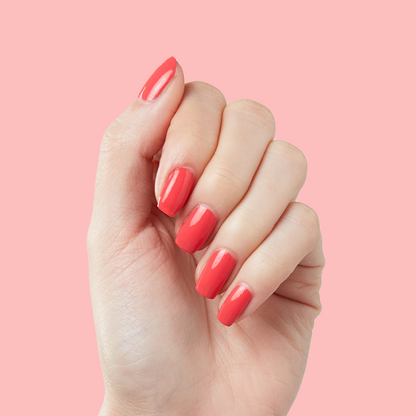 Hand with smooth nails painted in Field Day juicy watermelon red for a bright, long-lasting manicure look