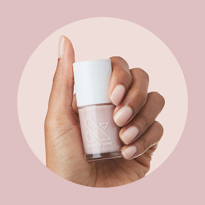 Hand holding Soap Nails Long-Lasting Mani System bottle with soft pink neutral nail polish shade close-up