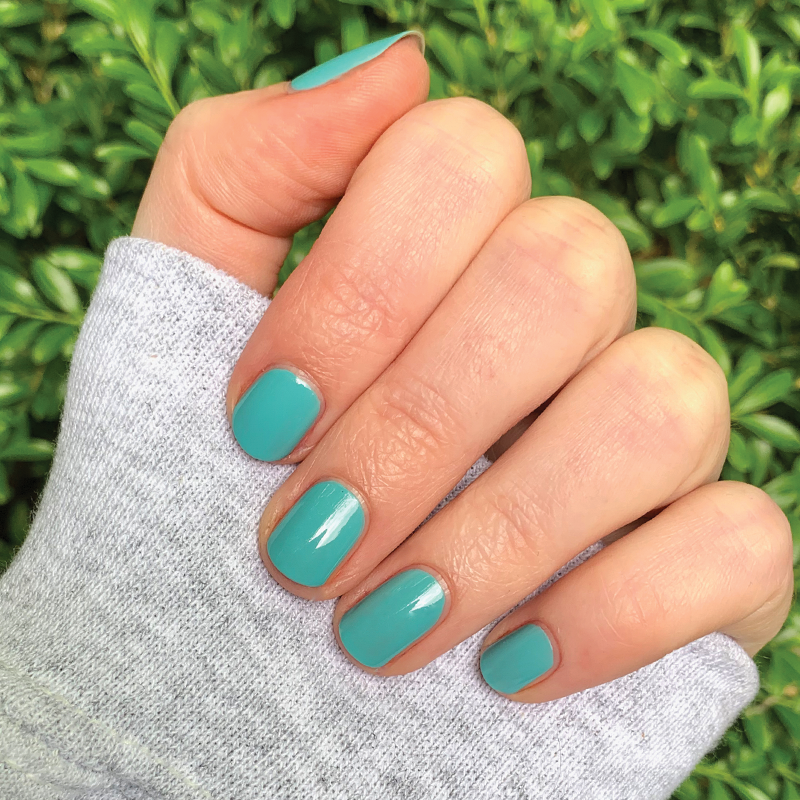 Hand with nails painted in glossy turquoise shade Yes Please for a smooth and long-lasting manicure by Olive and June