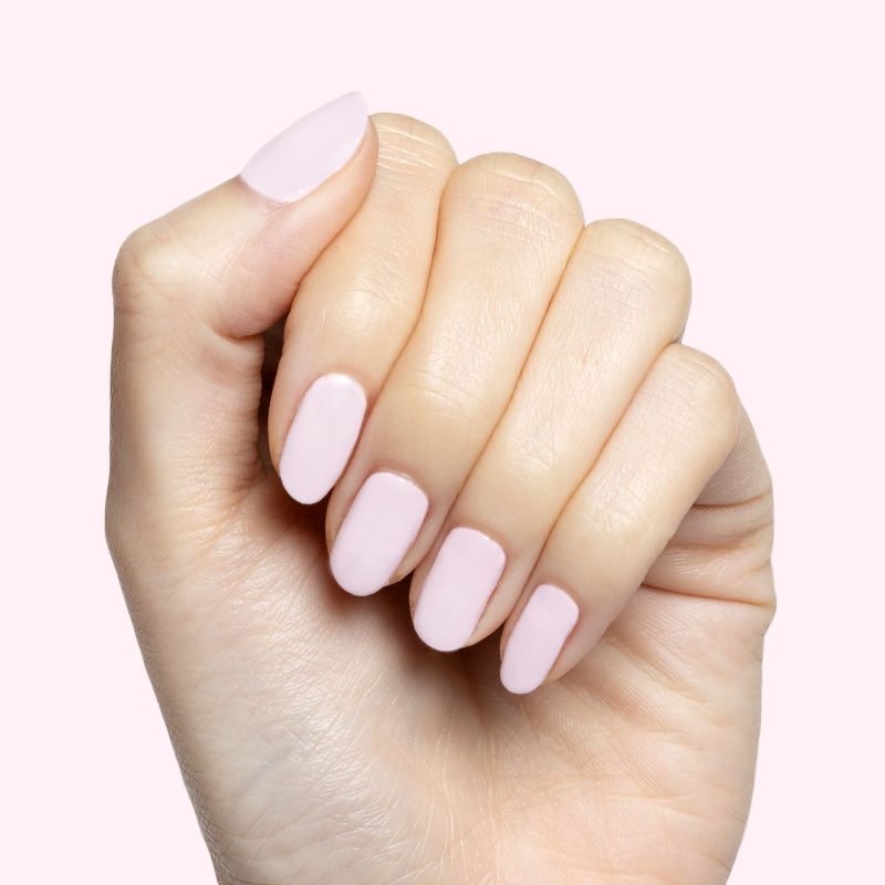 Hand with soft baby pink Gelato gel polish on short oval nails for a delicate, at home manicure look