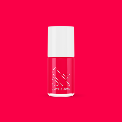Bottle of Olive and June Hibiscus polish in bright tropical pink on vibrant pink background for mani or manicure.