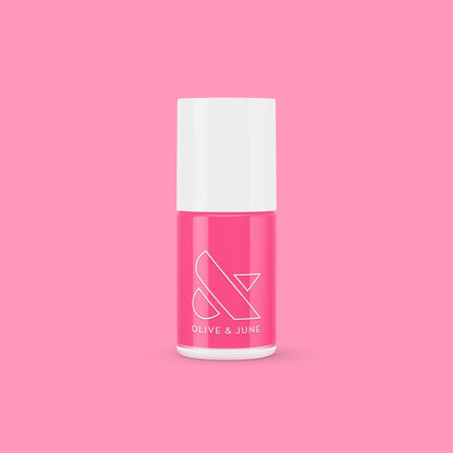 Olive and June Hot Strawberry gel polish bottle in bright strawberry pink against a matching pink background
