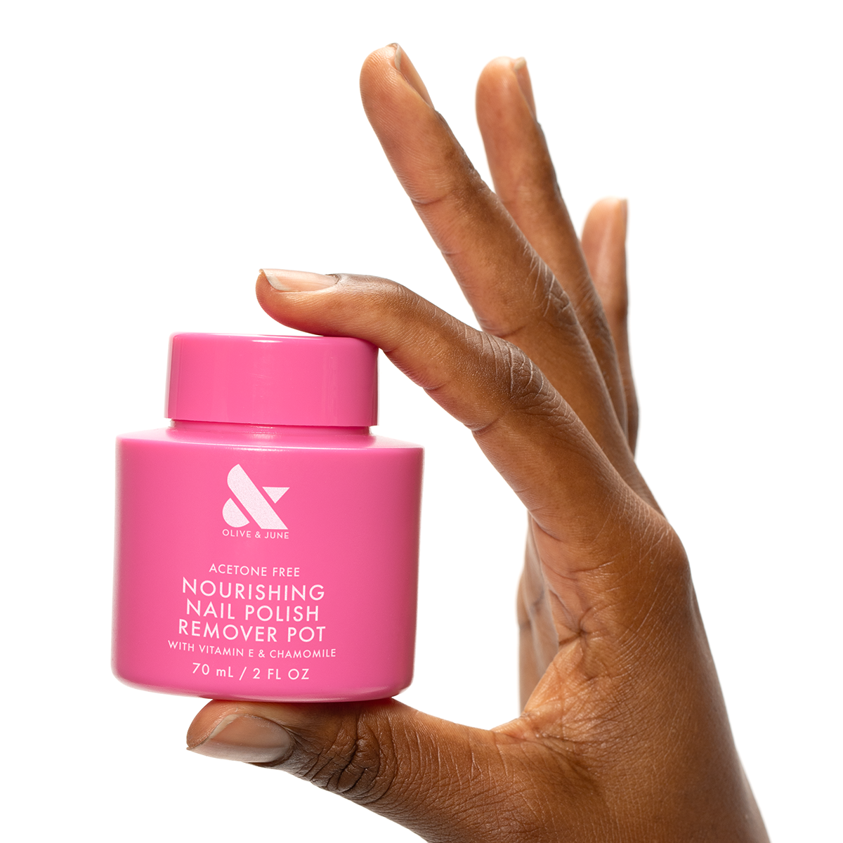 Hand holding a bright pink Nourishing Remover Pot with vitamin E and chamomile for easy nail polish removal