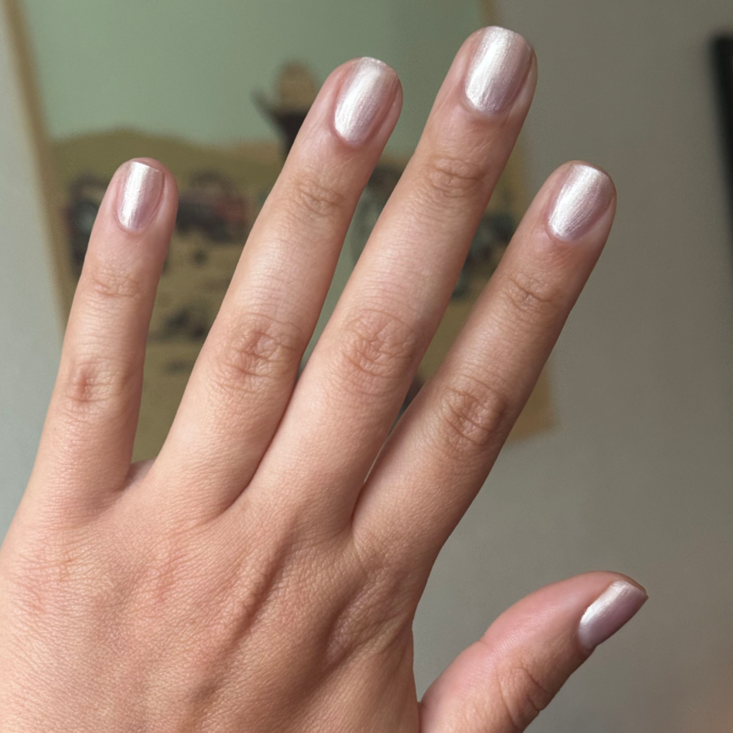 Hand with nails painted in soft shimmering sheer pink using Supernova quick dry gel polish manicure