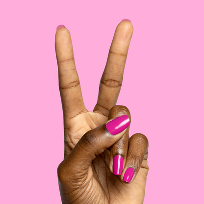 Hand with glossy bright pink nails making a peace sign against pink background with Speed Gloss Top Coat